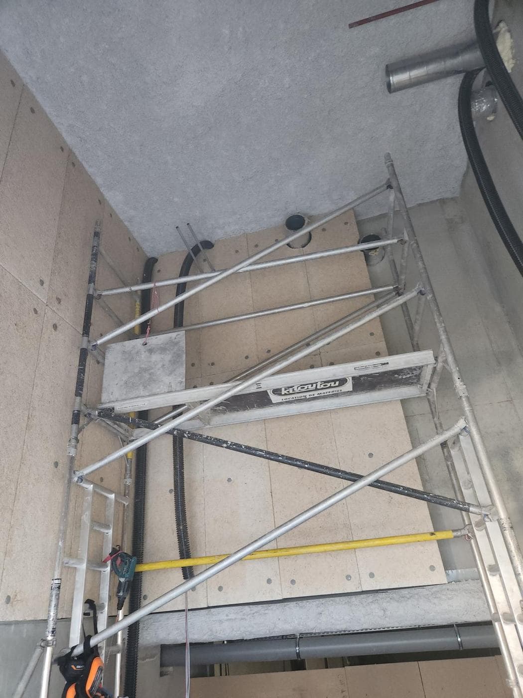 Pose de panneaux isolants verticaux — Pose en cours, échafaudage roulant